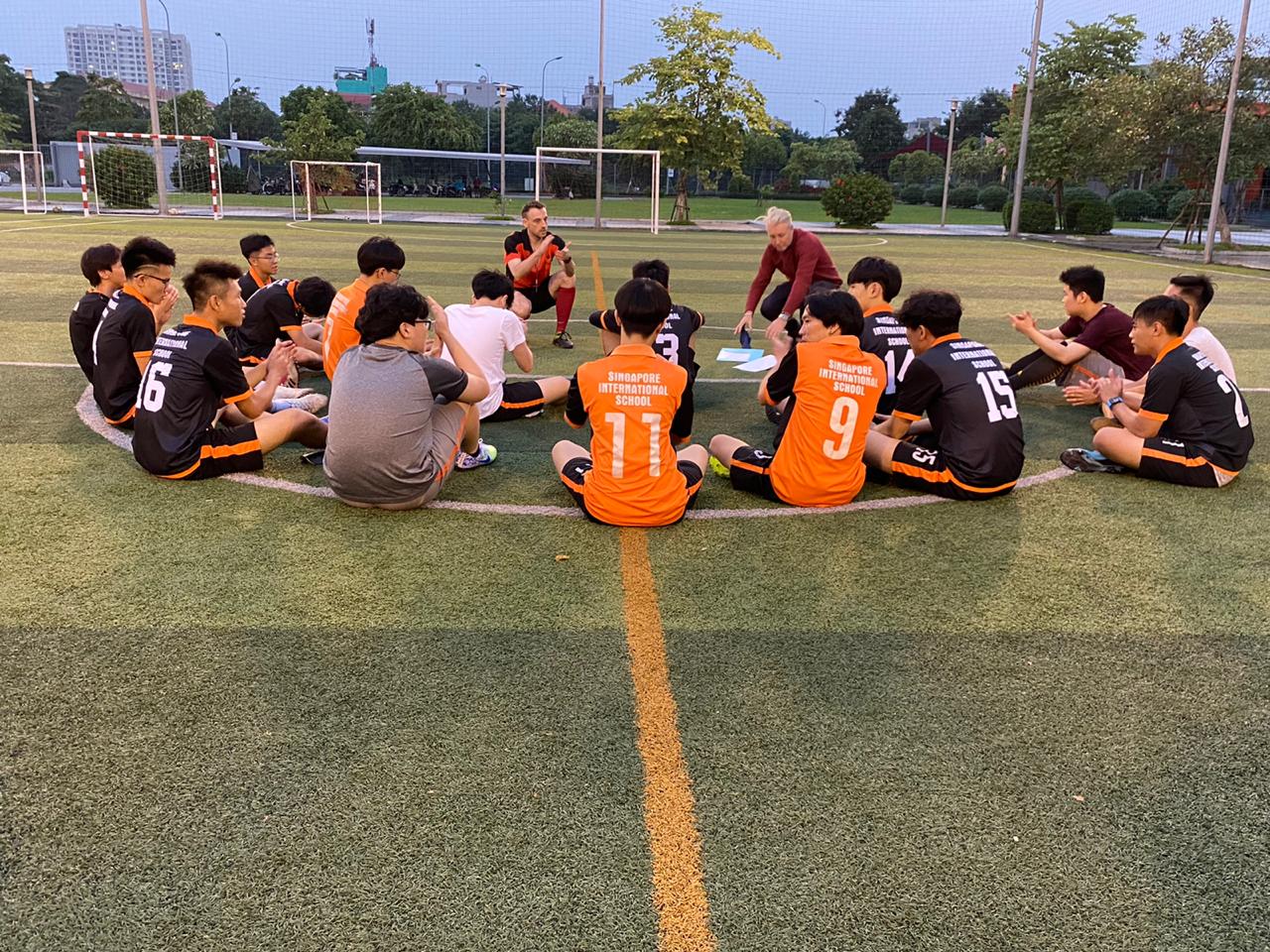 Patrick Flynn holding a championship banner with the Hanoi Sports League High School Boys Football team