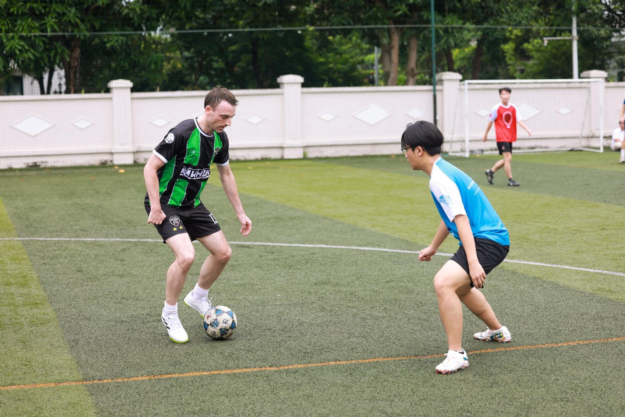 Patrick Flynn playing football against students